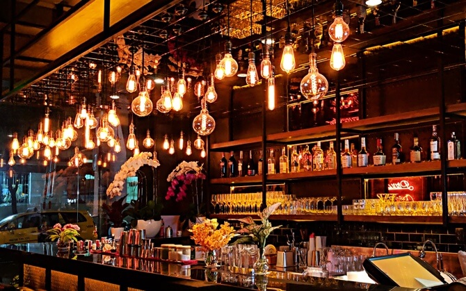 side shot of bar with hanging light bulbs